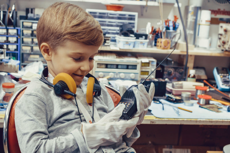 Young operator using amateur radio equipment transceiver setup requiring specific coaxial connectors for reliable HF/VHF comms.